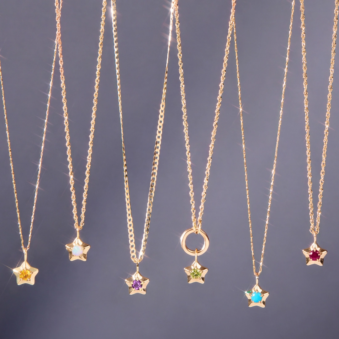 Six silver and gold necklaces with decorative pendants displayed against a dark green background, including &ldquo;THE LOVERS&rdquo; and &ldquo;THE MOON&rdquo; tarot-style pendants.