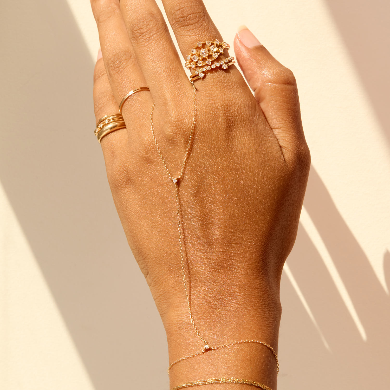Close-up of an ear with multiple gold piercings: a large hoop, a star stud, a twist design, a small stud, and a diamond-shaped stud. Warm lighting adds a stylish, elegant tone.